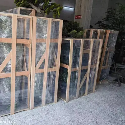 Large artificial trees packed in wooden frames.