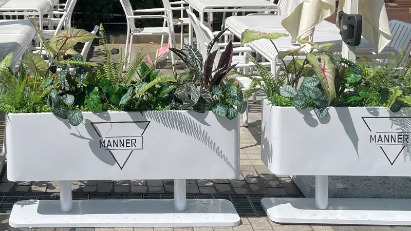 Artificial planter display Artificial plants in white rectangular planters, outdoor seating decor