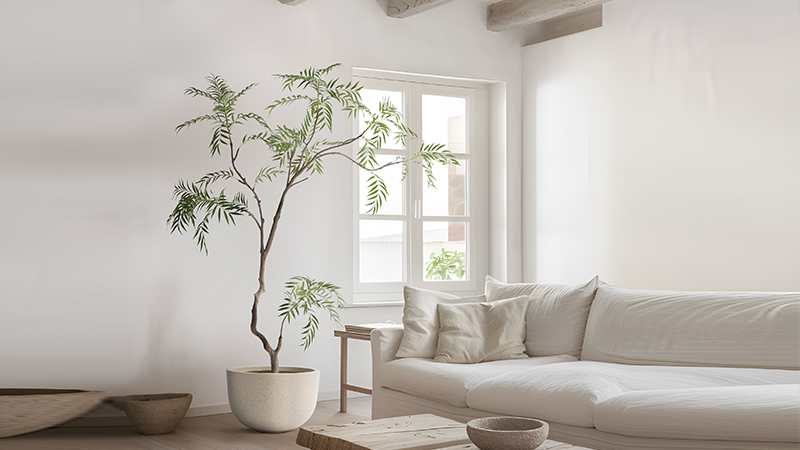 Artificial tree decor Elegant artificial tree with slender branches in a bright minimalist living room featuring white furniture and wooden accents.