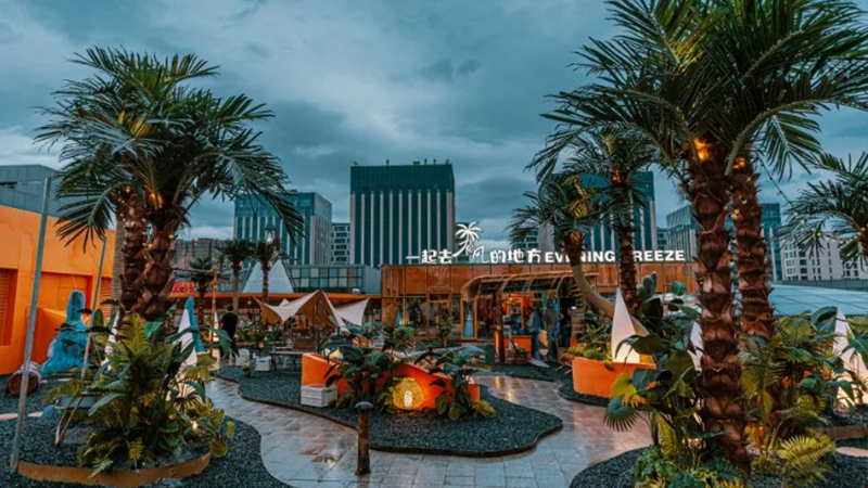 night view of urban outdoor lounge with palm trees and city lights