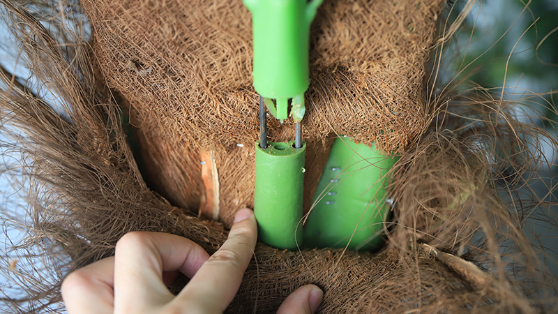 Close-up of artificial palm tree trunk with green connector, showing product assembly details