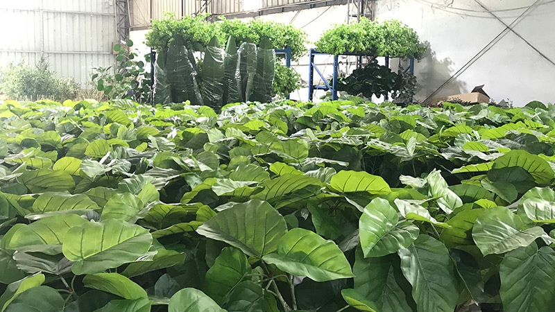 Artificial plant stock Artificial plant warehouse, green leaves, bulk storage
