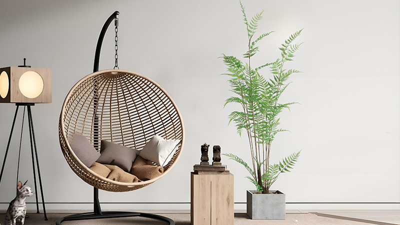 Cozy hanging chair decor Boho-style hanging rattan chair with plant and sculpture