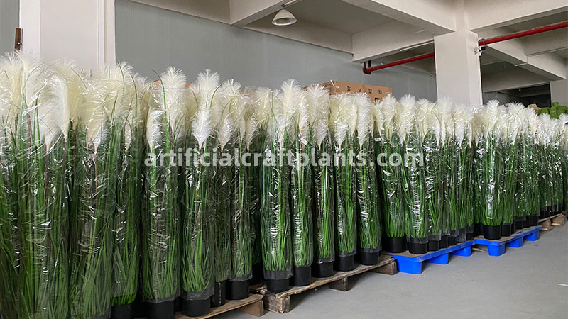 rows of artificial pampas grass in a warehouse