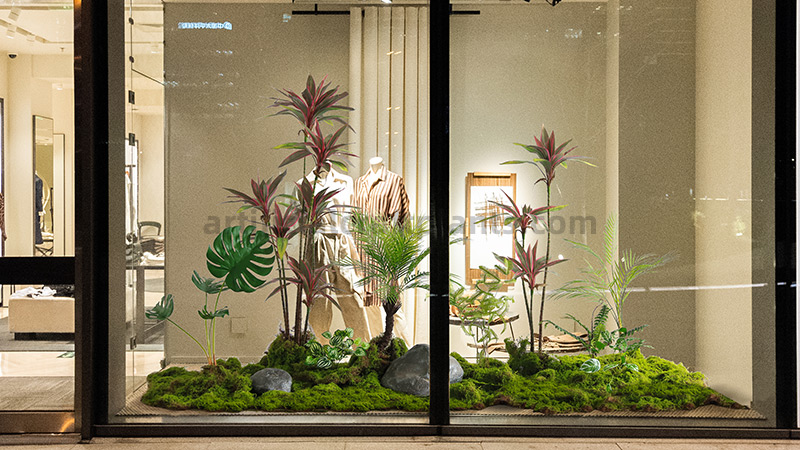 Store window display with artificial tropical plants and moss