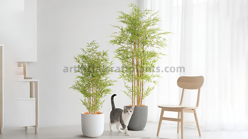 Artificial Bamboo Plants Two artificial bamboo plants in modern pots with a cat walking between them in a bright room.