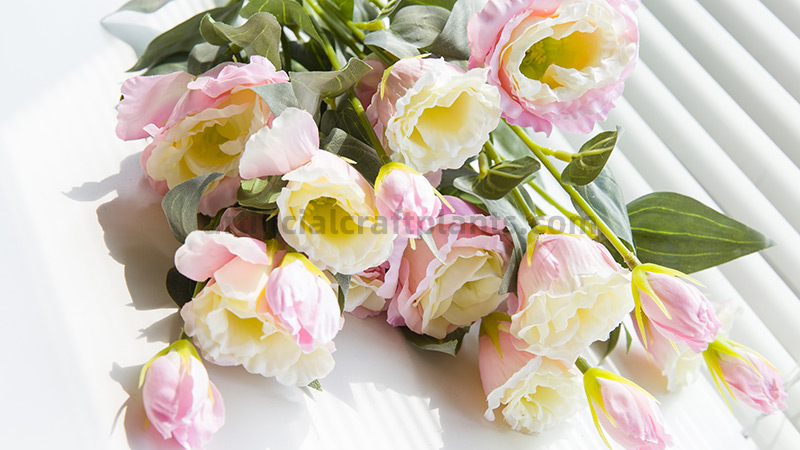 Artificial Eustoma Flowers Pink and white artificial Eustoma flowers with green leaves on a white background.