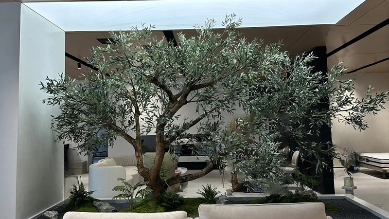 large artificial loquat tree in a modern living room with a cat
