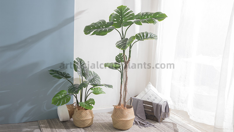 Artificial Monstera Plants two artificial monstera plants in woven baskets in a living room