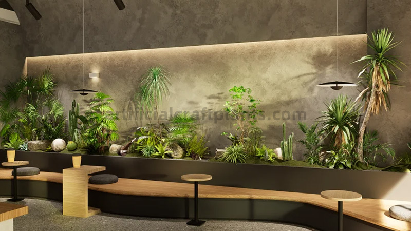 Indoor garden with various artificial plants and cacti in a cafe.