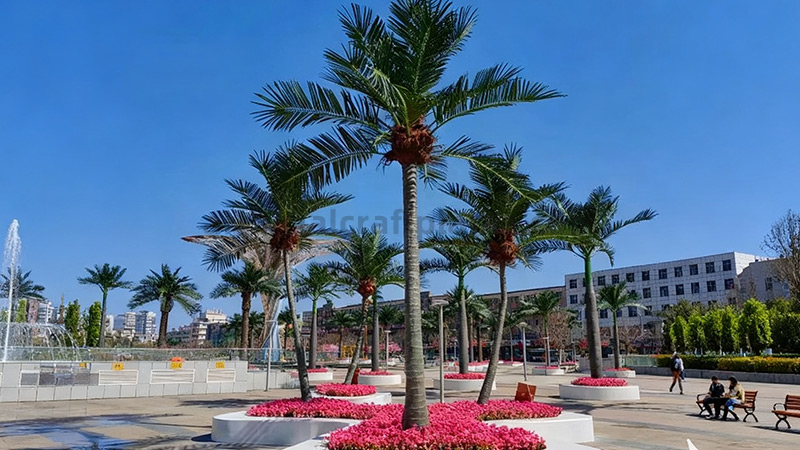 Artificial palm trees and fountain Fountain area with artificial palm trees and vibrant pink flowers