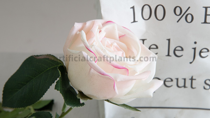 Artificial white pink rose Close-up of a single artificial white and pink rose against paper background