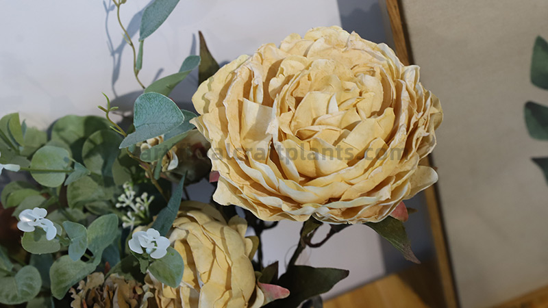 Artificial yellow peony bouquet Close-up of a large artificial yellow peony with eucalyptus leaves