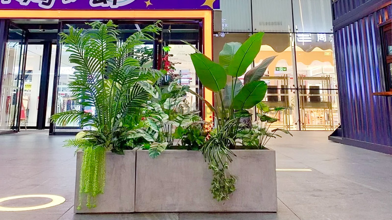Modern Mall Planter Lush artificial tropical plants in modern gray planter inside a mall