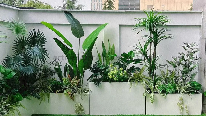 Lush artificial tropical plants in modern white planters