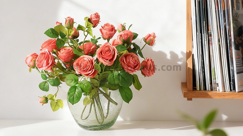 Faux Coral Roses Artificial coral rose arrangement in clear round glass vase on a shelf