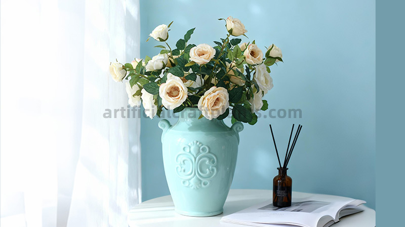 Faux Cream Roses Artificial cream roses in a celadon ceramic vase on white table